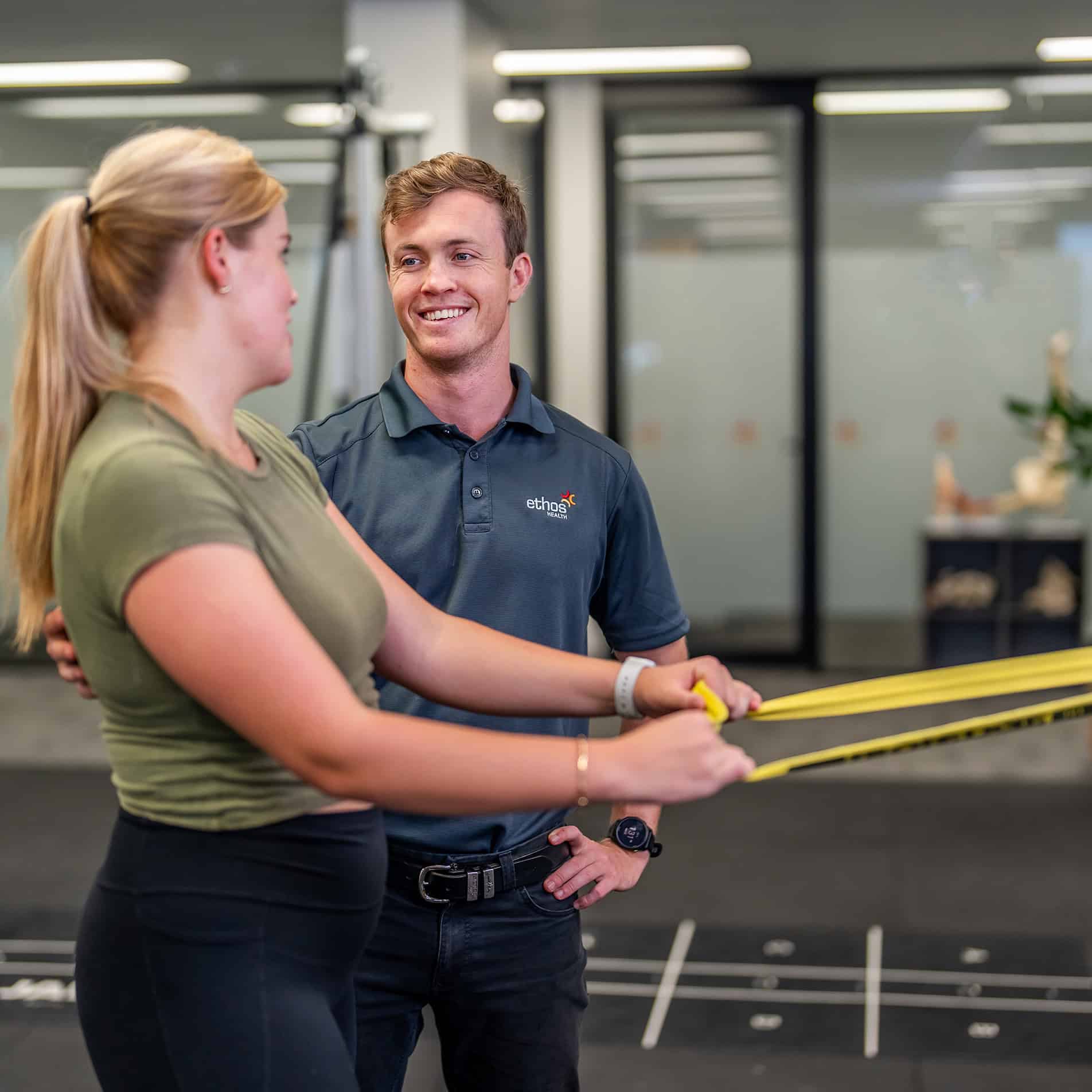 A client working with a physiotherapist on her exercises